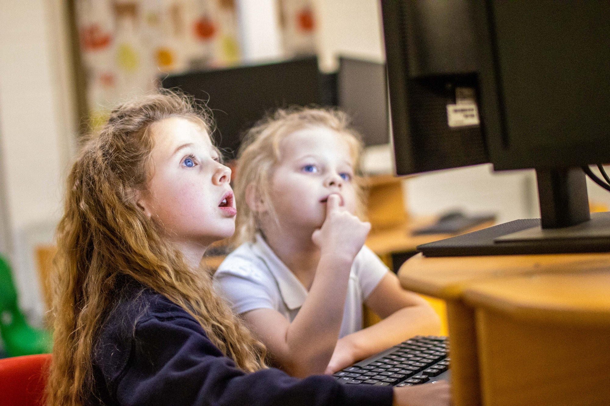 Girls use school computers.