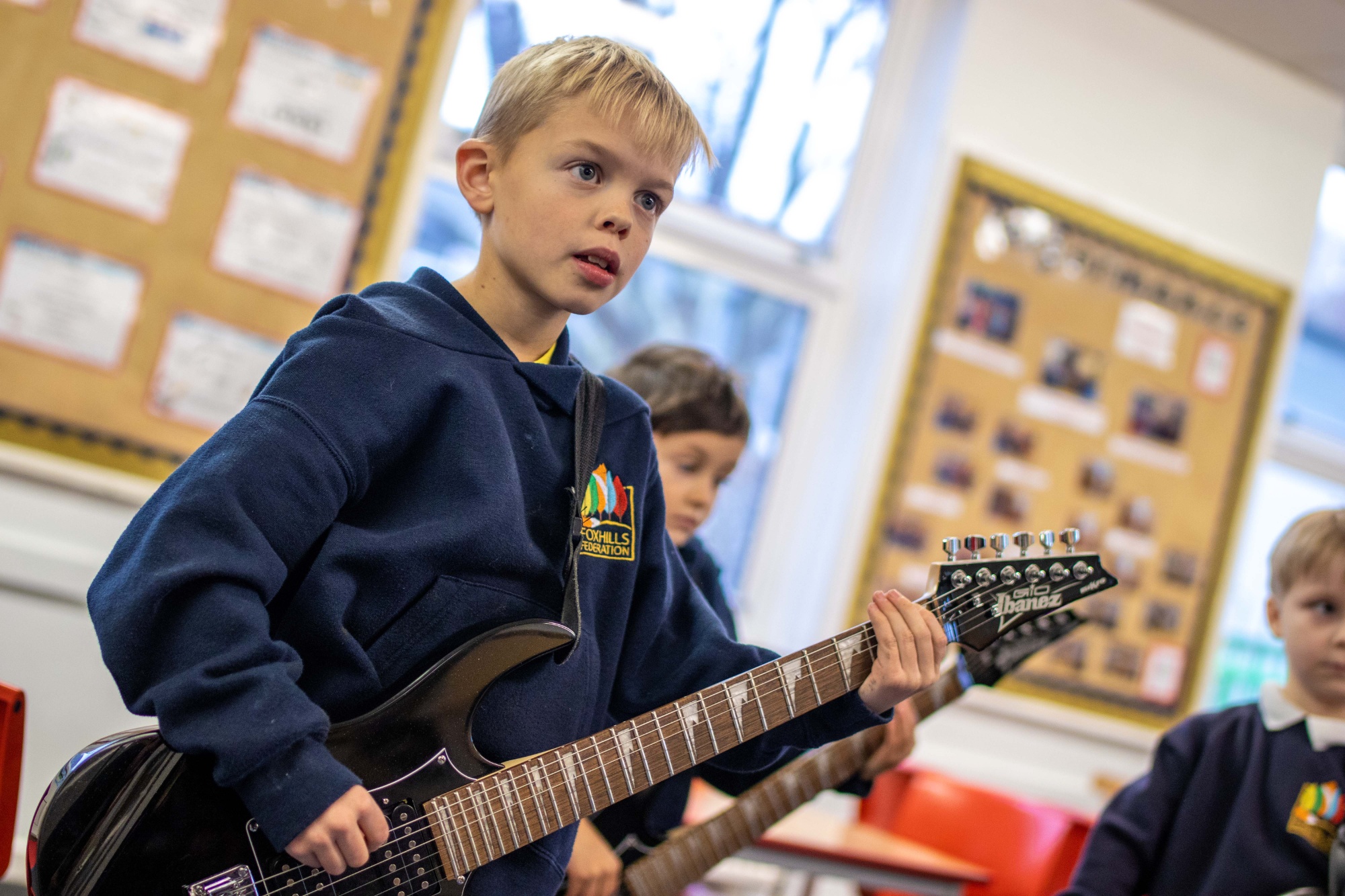 A boy play an electric guitar.