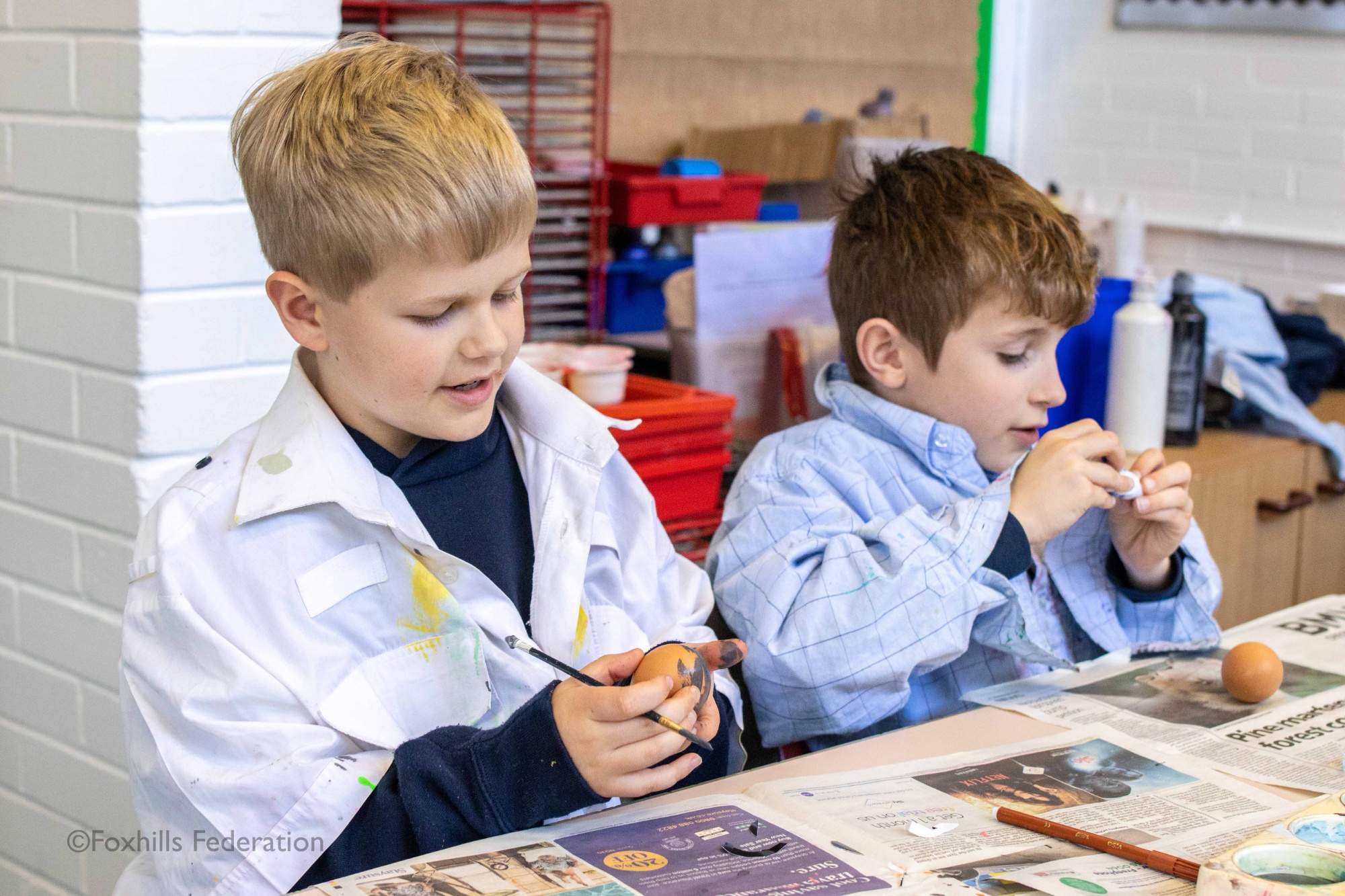 Two boys paint eggs