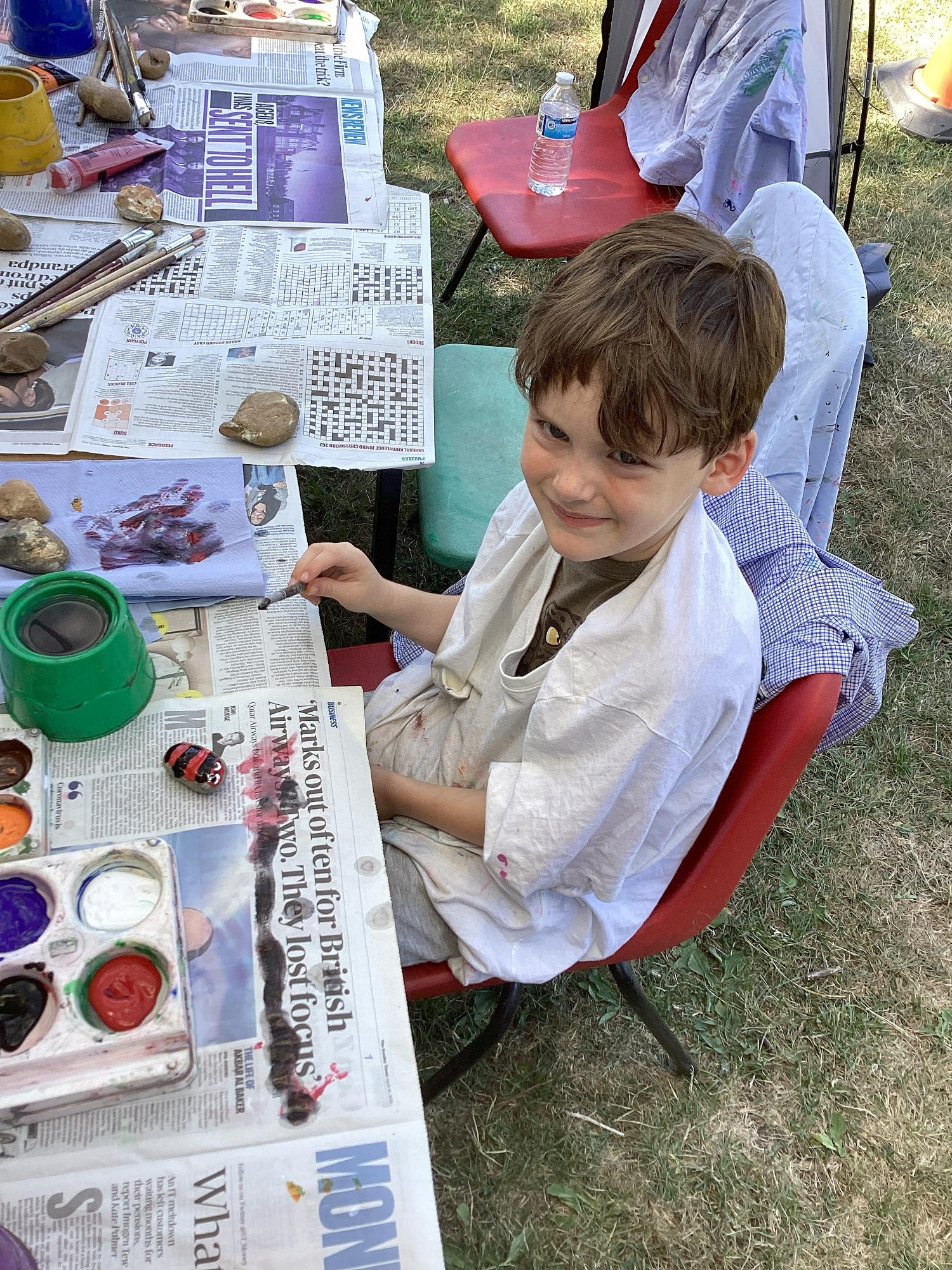 A boy paints and smiles