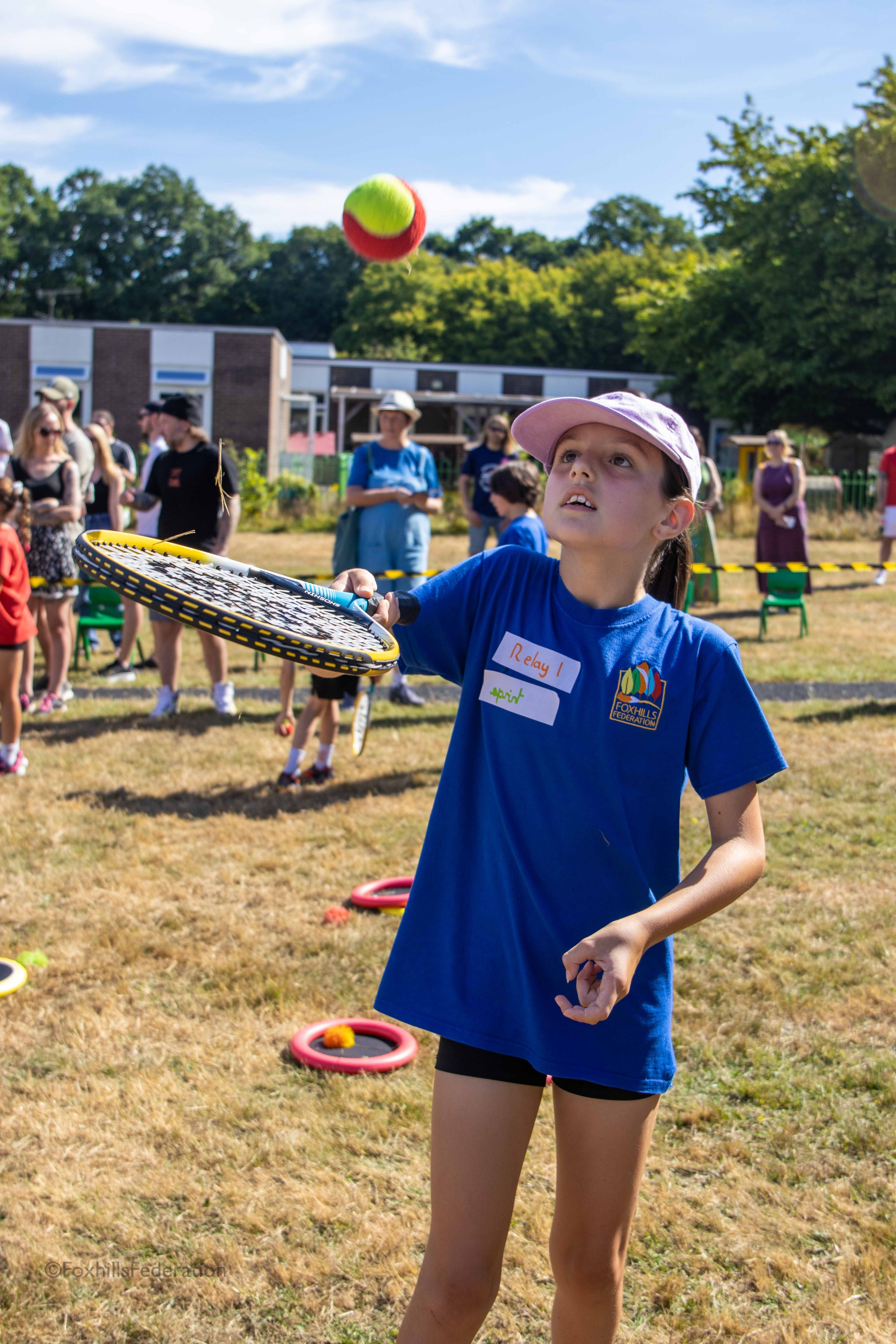 A girl tries to catch a ball on a tennis racket