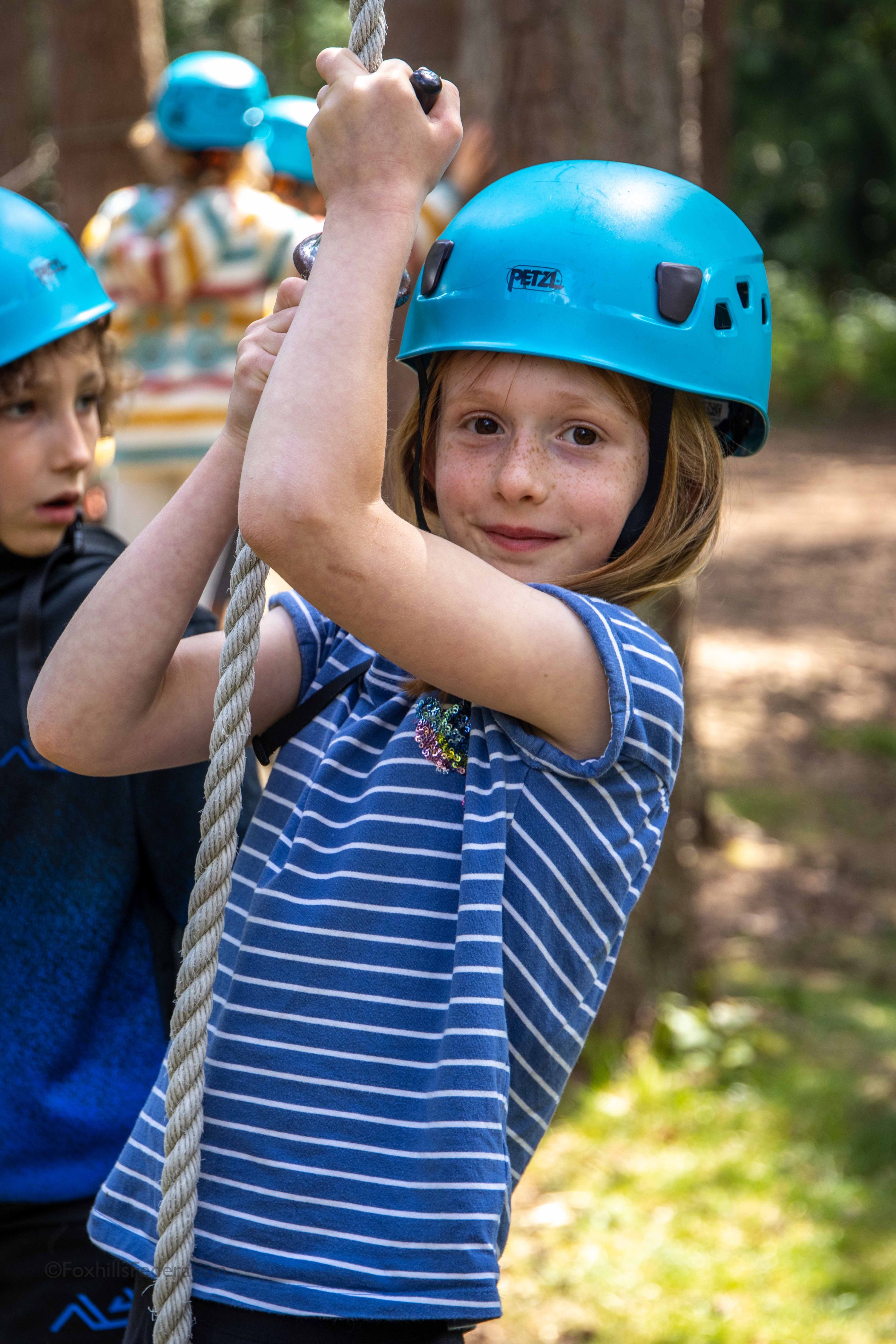 A girl hangs onto a rope
