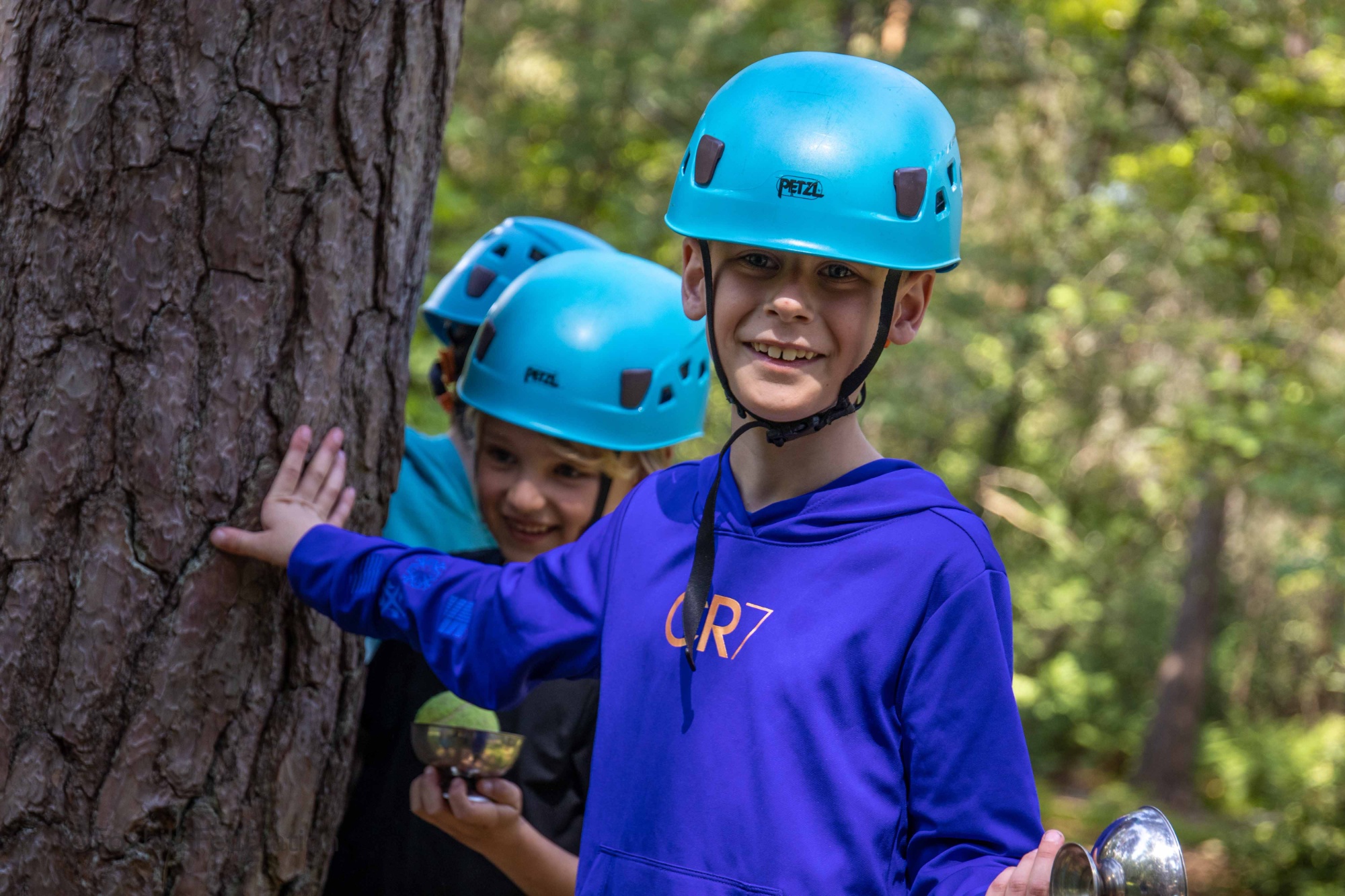 A boy smiles on a low ropes course