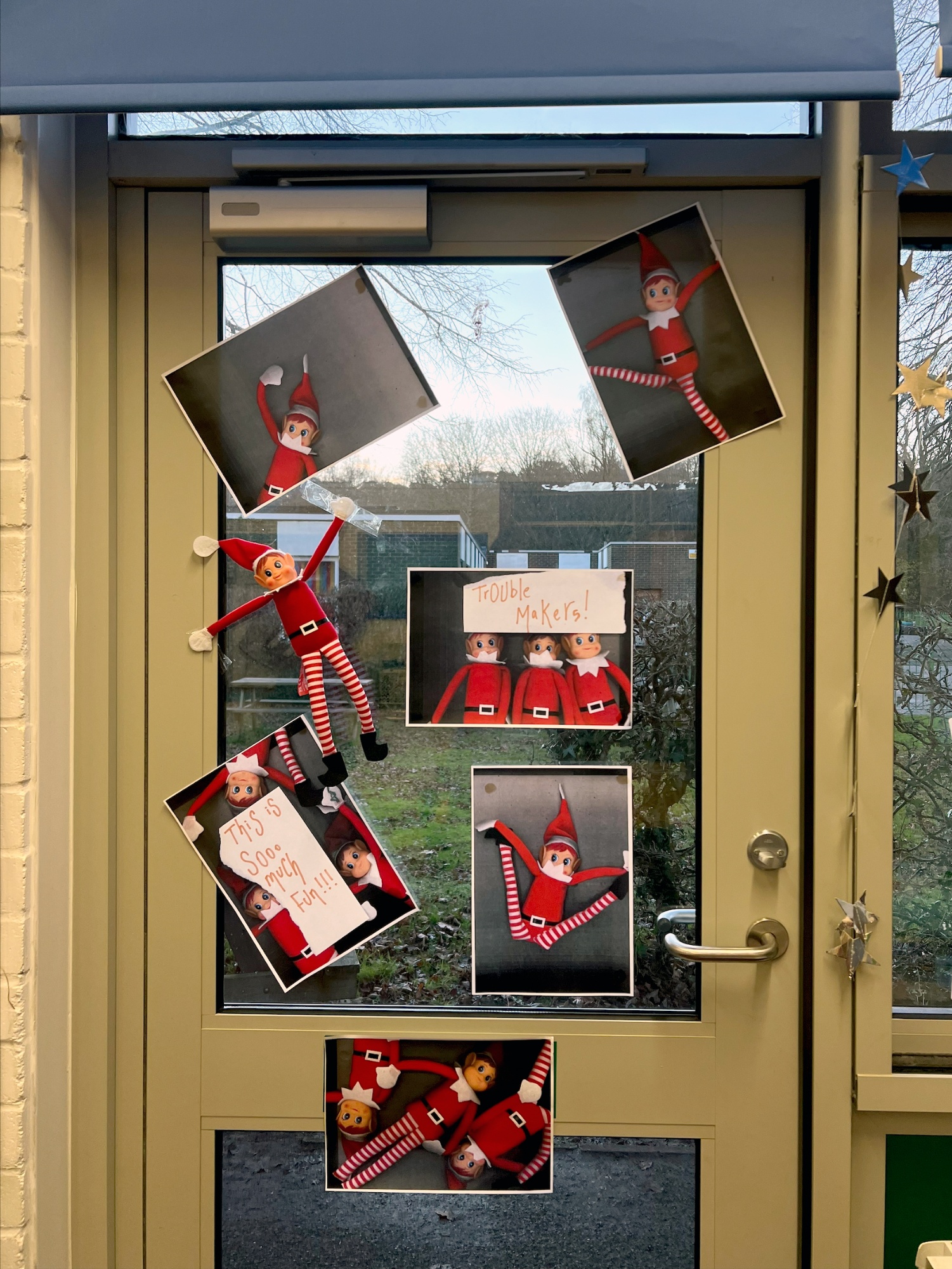 Printed images of elves stuck onto a classroom door.