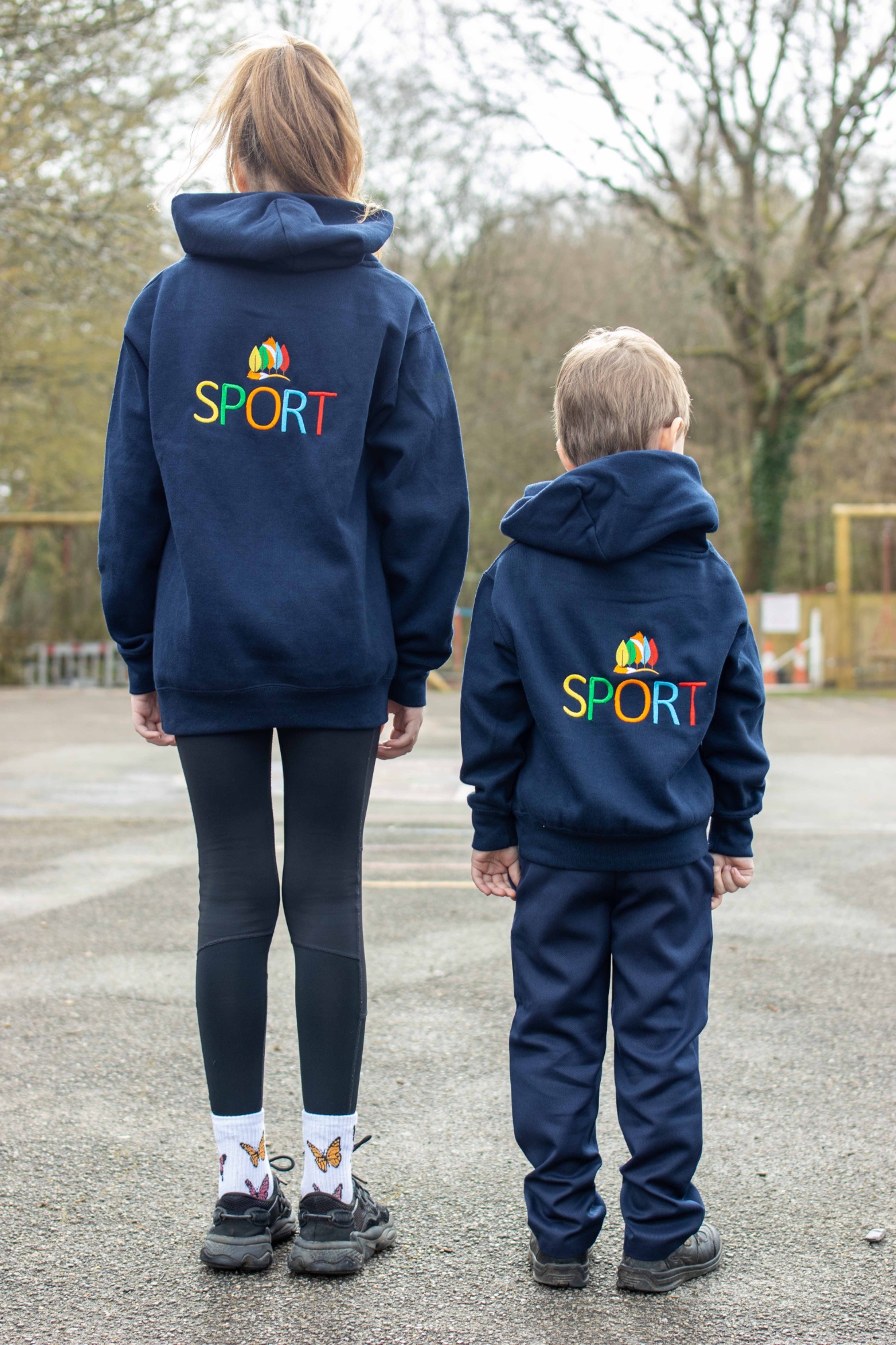 A boy and girl showing the correct PE kit.