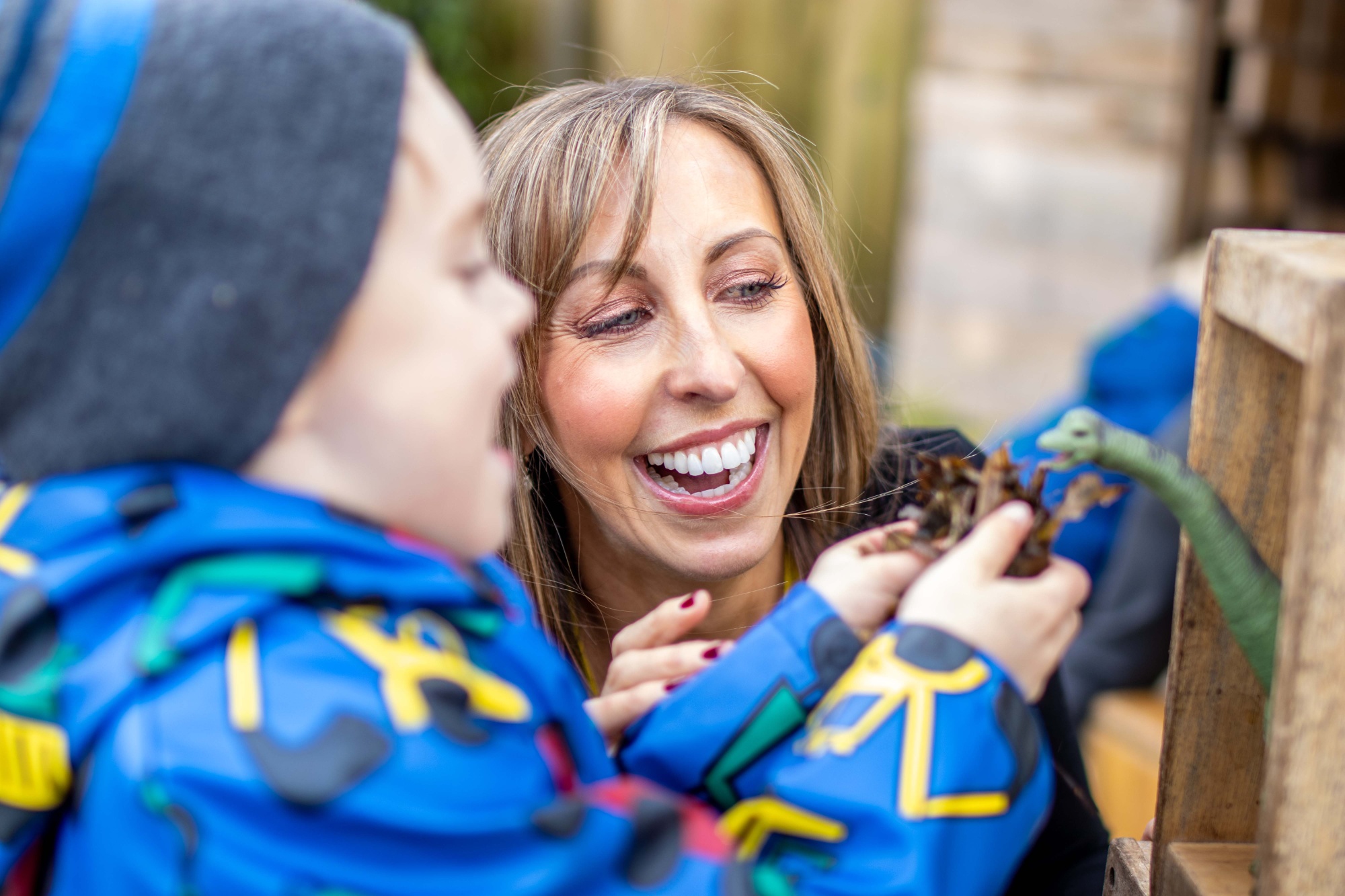 A boy shows Headteacher Lucy Howe a toy dinosaur.