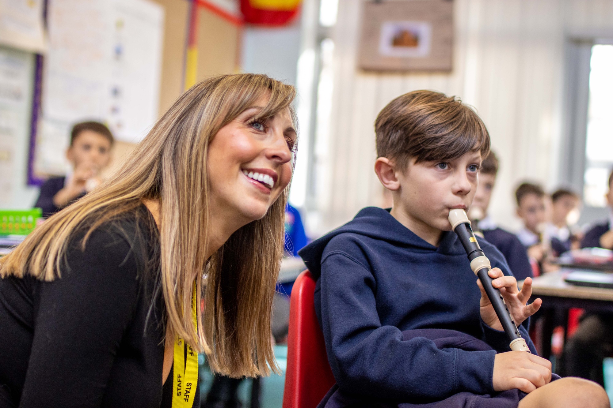 Headteacher Lucy Howe listens to a child playing the Recorder.